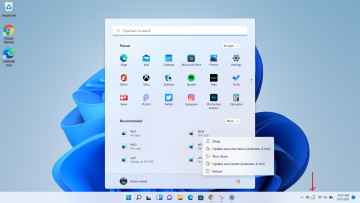 Windows 11 desktop open with Windows Update pending arrow on icon in Taskbar