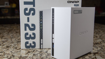 Front view of QNAP TS-233 next to the box it came in